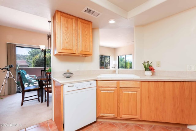 kitchen featuring kitchen peninsula, tile counters, light tile patterned floors, white dishwasher, and sink