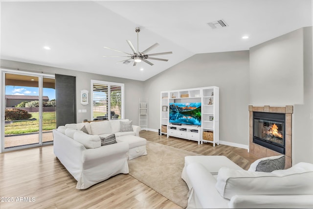 18822 E Flintlock Dr, Queen Creek, AZ 85142 - living room with ceiling fan, light wood-type flooring, lofted ceiling, a tile fireplace, and visible vents