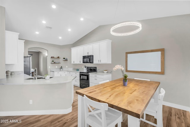 18822 E Flintlock Dr, Queen Creek, AZ 85142 - kitchen featuring open shelves, white cabinetry, arched walkways, light wood-style flooring, and black appliances
