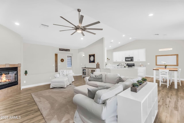 18822 E Flintlock Dr, Queen Creek, AZ 85142 - living area with light wood-style floors, baseboards, a ceiling fan, and a tile fireplace