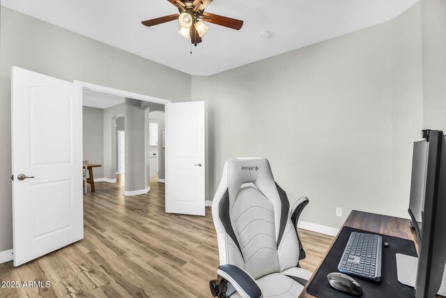18822 E Flintlock Dr, Queen Creek, AZ 85142 - office area with arched walkways, ceiling fan, baseboards, and light wood-style floors