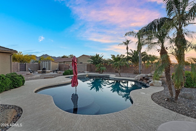 18822 E Flintlock Dr, Queen Creek, AZ 85142 - pool at dusk with a patio, a fenced in pool, and a fenced backyard
