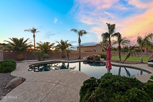 18822 E Flintlock Dr, Queen Creek, AZ 85142 - pool at dusk with a patio, a diving board, a fenced in pool, and a fenced backyard
