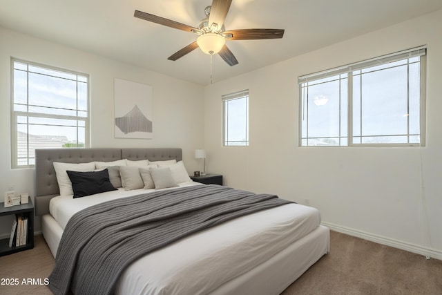 bedroom with a ceiling fan, baseboards, and carpet floors