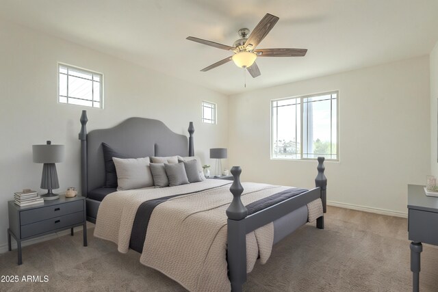 bedroom with light carpet, multiple windows, and baseboards