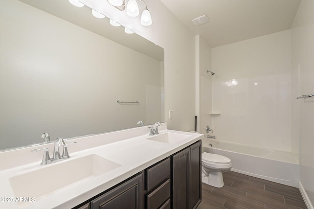 full bath with a sink, shower / bathing tub combination, wood finish floors, and toilet