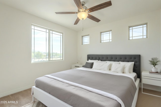 bedroom with baseboards, light carpet, and a ceiling fan