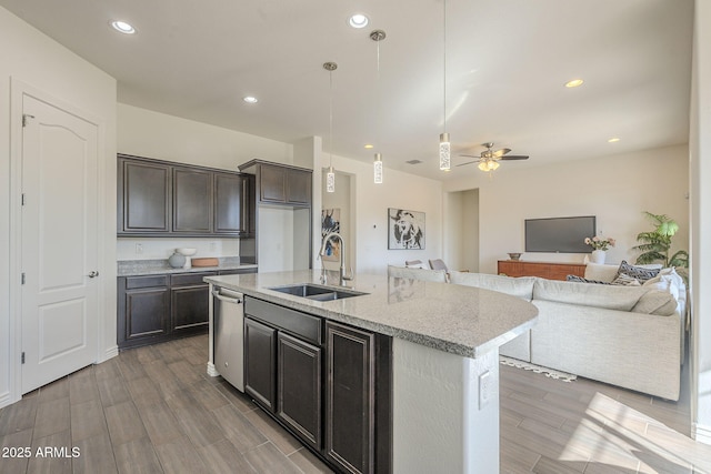 kitchen featuring ceiling fan, decorative light fixtures, open floor plan, dishwasher, and a sink