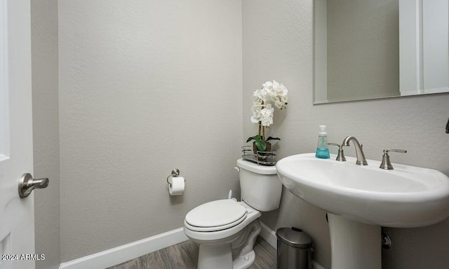 bathroom featuring hardwood / wood-style floors and toilet