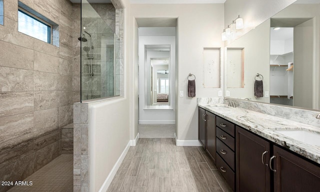 bathroom featuring a tile shower and vanity