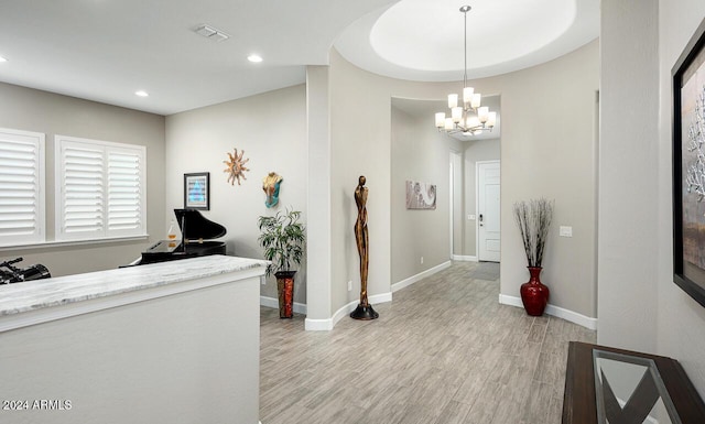 entryway with light hardwood / wood-style flooring and a notable chandelier