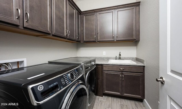 washroom with separate washer and dryer, sink, and cabinets