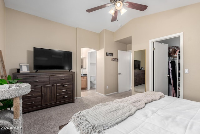 bedroom with lofted ceiling, ensuite bath, ceiling fan, a spacious closet, and light colored carpet