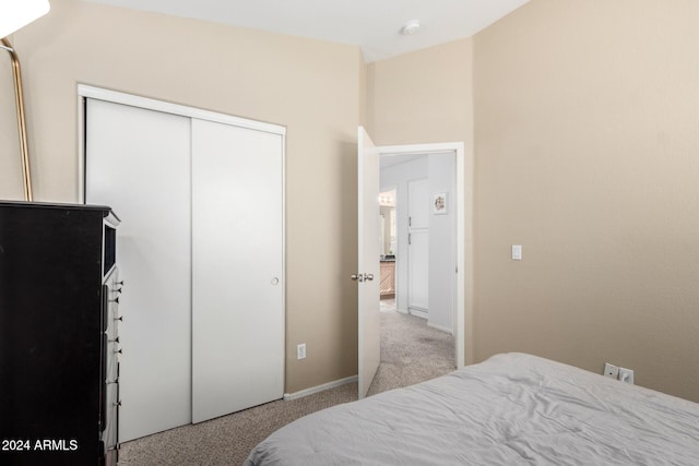 bedroom featuring light carpet and a closet