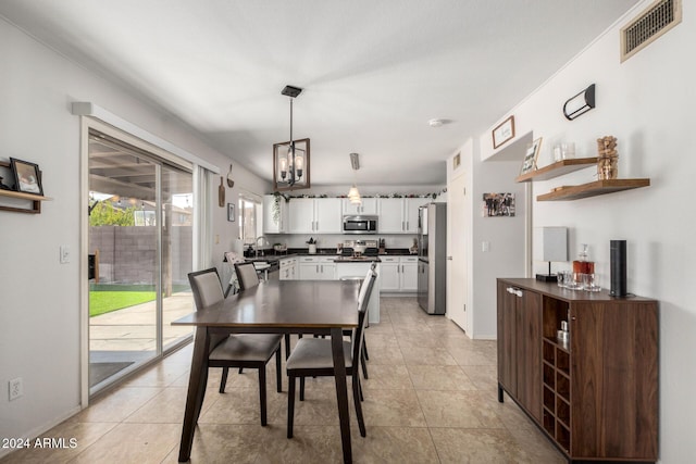 tiled dining space with sink and an inviting chandelier