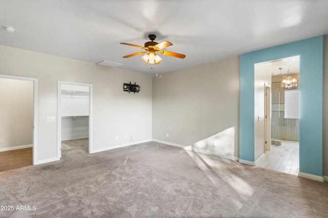 empty room with light carpet and ceiling fan with notable chandelier