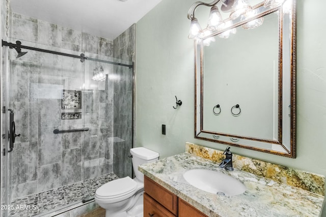 bathroom featuring toilet, vanity, and an enclosed shower