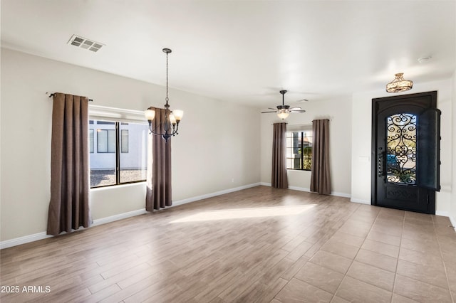 foyer entrance featuring ceiling fan with notable chandelier and light hardwood / wood-style floors