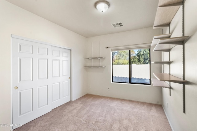 unfurnished bedroom featuring a closet and light carpet