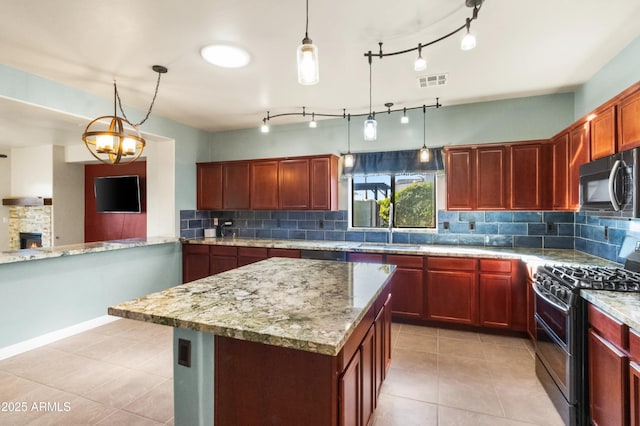 kitchen featuring double oven range, light stone countertops, pendant lighting, and sink