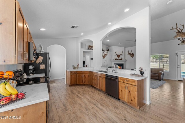 kitchen featuring kitchen peninsula, sink, ceiling fan, black dishwasher, and light hardwood / wood-style floors