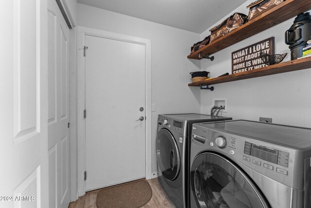 washroom with washer and clothes dryer and light hardwood / wood-style flooring