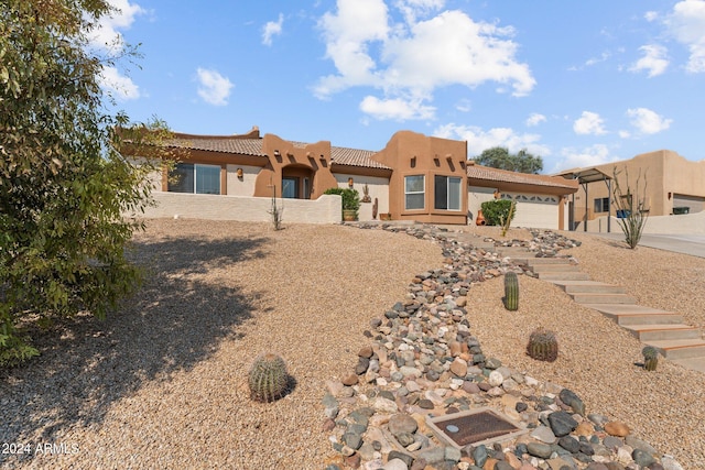 pueblo revival-style home featuring a garage