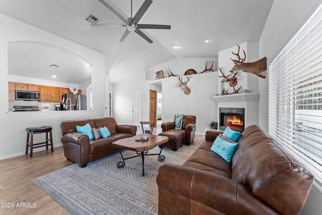 living room featuring light wood-type flooring, lofted ceiling, and ceiling fan