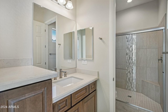 bathroom with vanity, toilet, and a shower with shower door