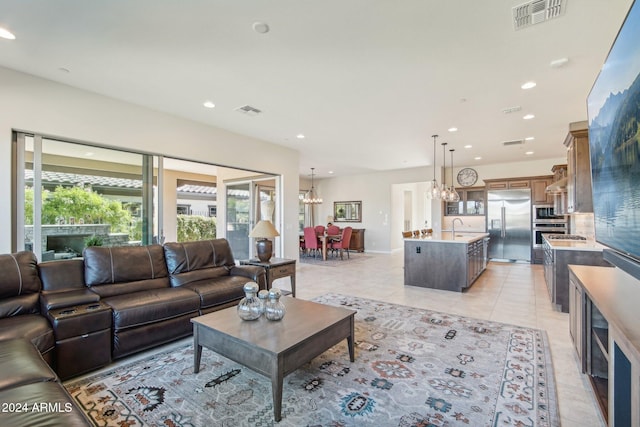 tiled living room featuring a notable chandelier and sink