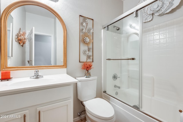 full bathroom with combined bath / shower with glass door, vanity, and toilet