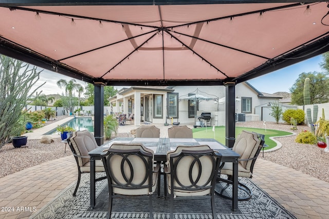 view of patio / terrace featuring area for grilling, central AC, a fenced in pool, and a gazebo