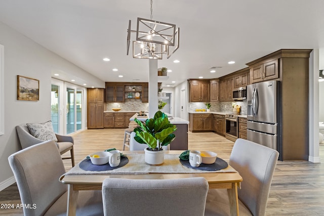 dining area with an inviting chandelier and light wood-type flooring