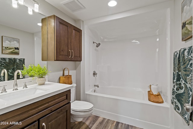 full bathroom with tub / shower combination, vanity, toilet, and wood-type flooring