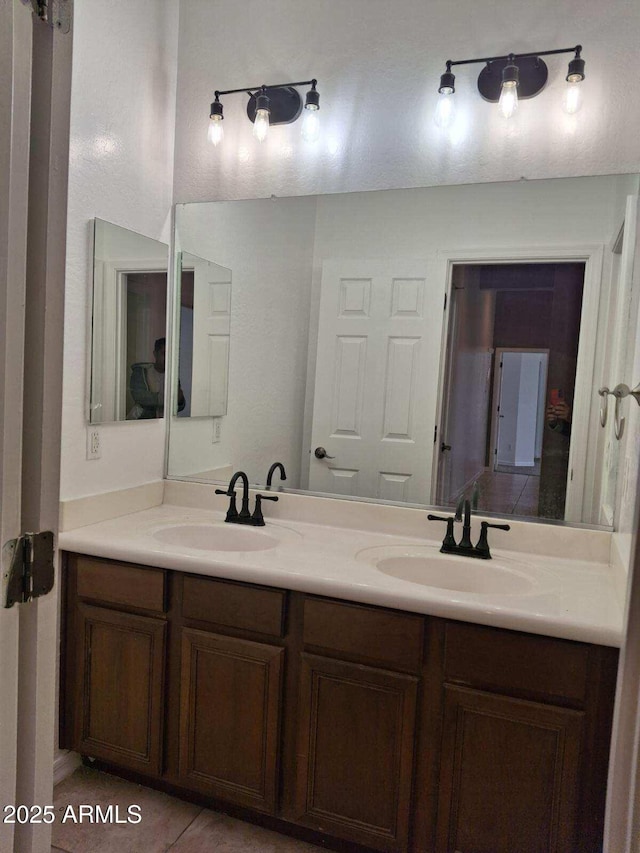 full bathroom featuring tile patterned flooring, double vanity, and a sink