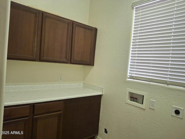 laundry room with hookup for an electric dryer and cabinet space