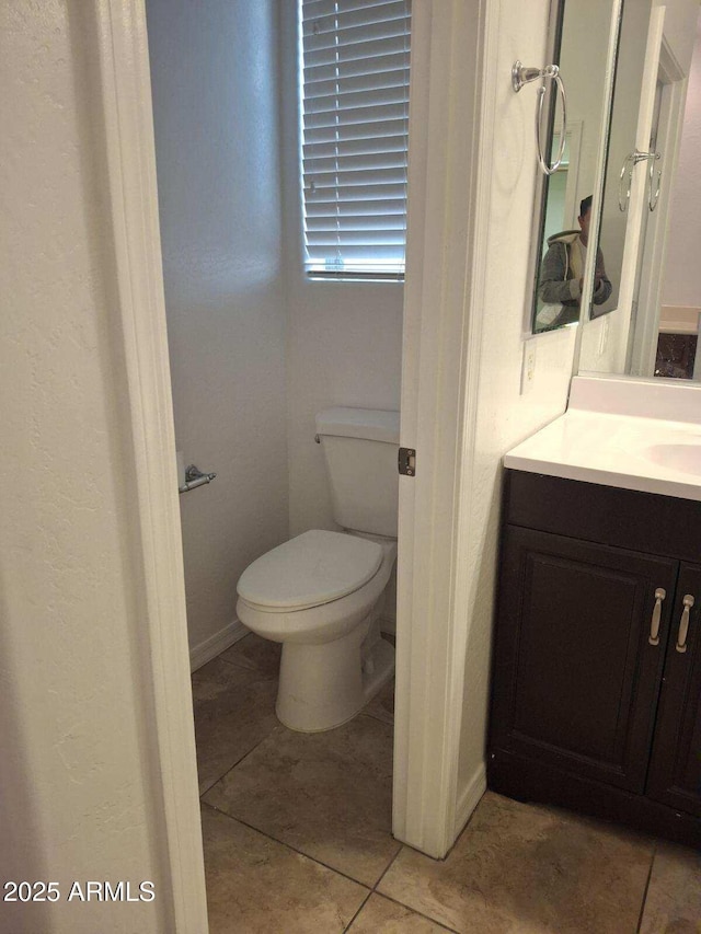 bathroom featuring toilet, vanity, and tile patterned flooring