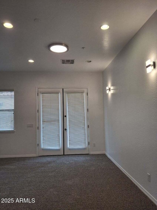 empty room with visible vents, carpet flooring, and baseboards