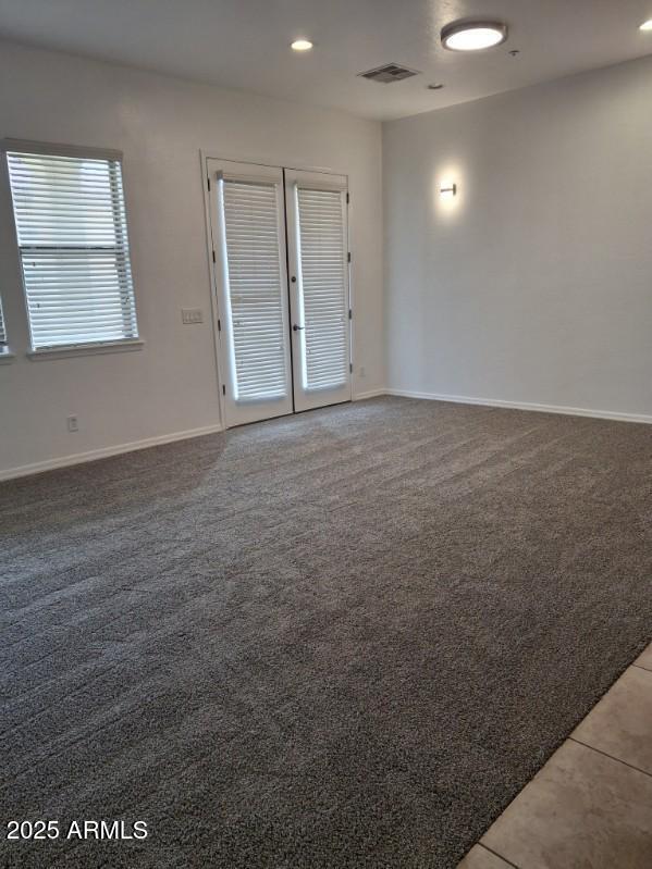 spare room featuring visible vents, recessed lighting, carpet flooring, and baseboards