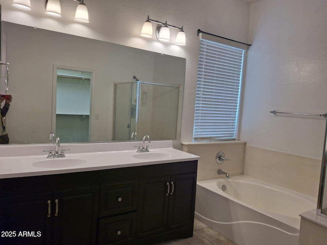 full bath with double vanity, a shower stall, a bath, and a sink