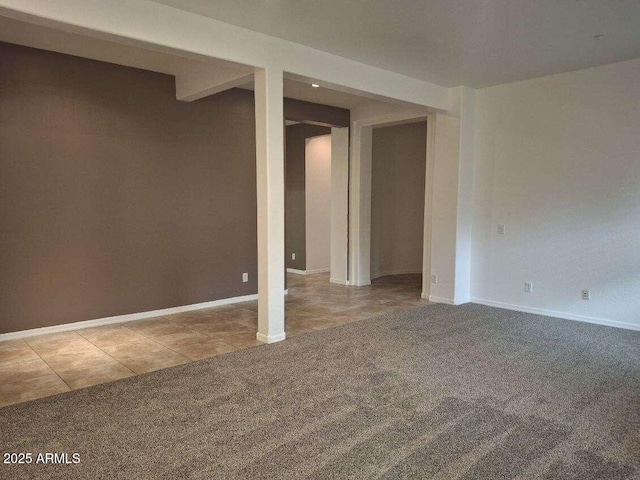 below grade area with baseboards, light tile patterned flooring, and light colored carpet