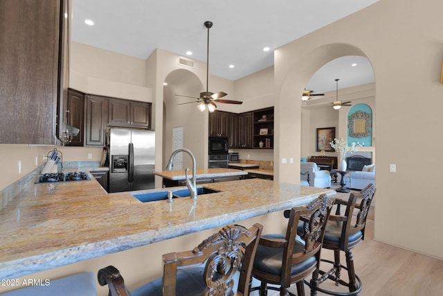 1940 N Stevens Cir, Mesa, AZ 85205 - kitchen with black appliances, a ceiling fan, dark brown cabinets, a peninsula, and recessed lighting