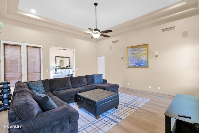 1940 N Stevens Cir, Mesa, AZ 85205 - living room with a tray ceiling, light wood-type flooring, a ceiling fan, recessed lighting, and french doors
