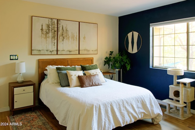 bedroom with dark hardwood / wood-style flooring