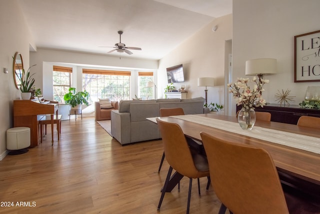 dining area with ceiling fan, lofted ceiling, and light hardwood / wood-style flooring