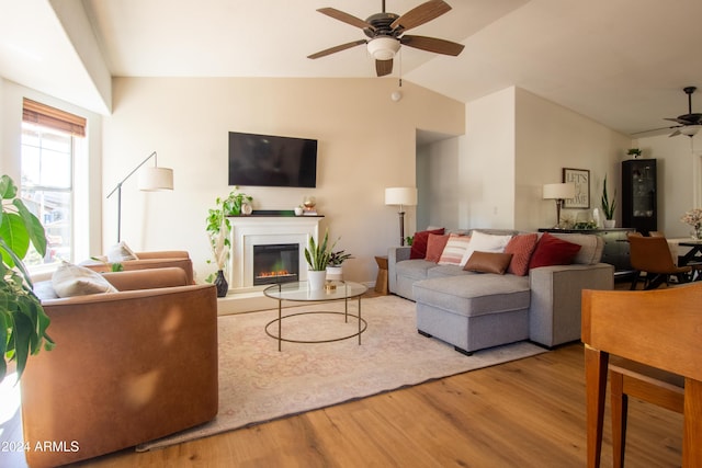 living room featuring light hardwood / wood-style floors, ceiling fan, and lofted ceiling