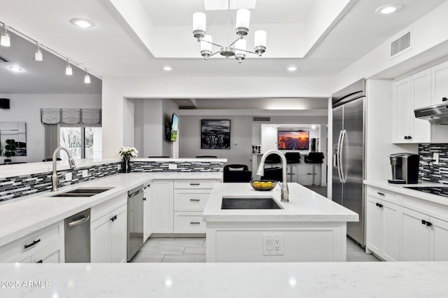 kitchen featuring sink, light stone countertops, a center island, and appliances with stainless steel finishes