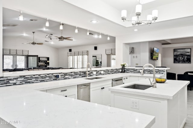 kitchen featuring white cabinetry, light stone countertops, sink, and decorative light fixtures