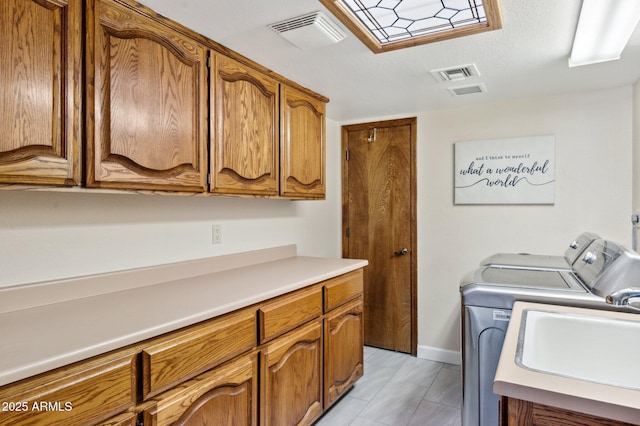 washroom featuring cabinets, sink, and independent washer and dryer