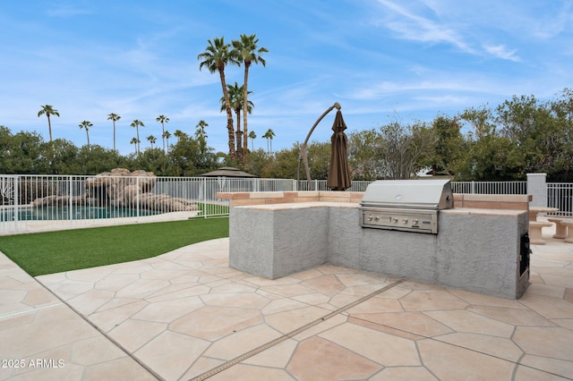 view of patio with a fenced in pool, grilling area, and an outdoor kitchen